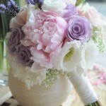 A beautiful Quinceañera dress and a bouquet of flowers in a vase on a table, offering ideas for Quinceanera colors