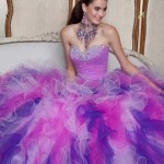 A woman sitting on a couch wearing a purple Quinceanera ball gown.