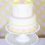 Quinceanera cake decorating, a white cake with a yellow bow on top