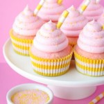 A plate of pink lemonade cupcakes with pink frosting and a cup of coffee, a Quinceanera dessert option