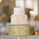 A Quinceanera cake, a three-tiered cake on a gold stand, covered in gold glitter