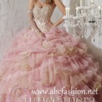 Quinceanera collection gold Quinceañera dresses, a woman in a ball gown posing for a picture