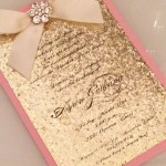 A pink and gold Quinceanera invitation with a bow