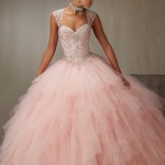 A woman in a pink Quinceañera gown posing for a picture