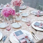 A Quinceanera-themed table set for a formal dinner with pink flowers