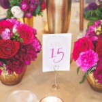 Quinceanera image: A table topped with vases filled with cut flowers, featuring a floral design with pink and red flowers.