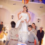 A woman in a Quinceanera gown standing on top of a man
