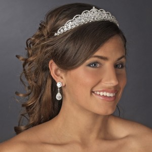A dainty tiara on a beautiful young woman, complemented by earrings.
