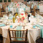 A table set up for a formal dinner with tiffany blue and coral Quinceanera theme.