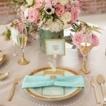 Quinceanera table set with mint and salmon colors, featuring a vase of flowers and place settings.