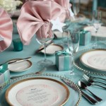 Quinceanera, a table set with plates and silverware in tiffany blue and rose gold