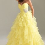 A woman in a yellow Quinceanera gown posing for a picture