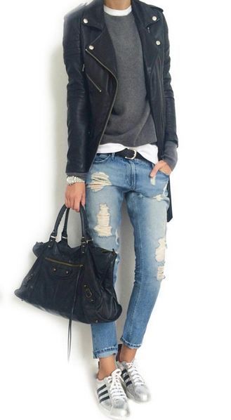A woman wearing ripped jeans and a black leather jacket