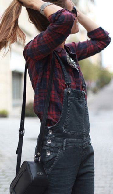 A woman wearing overall flannel outfit standing on a cobblestone street during a Quinceanera celebration.