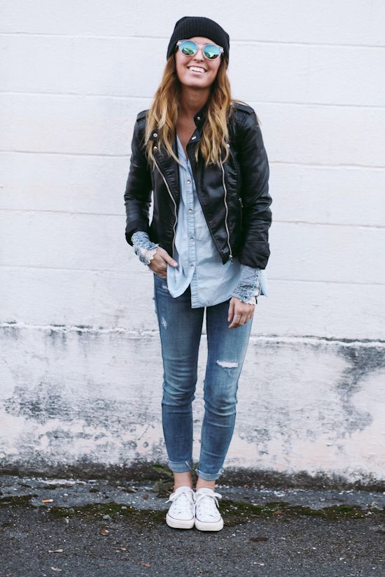 A woman wearing a black leather jacket and jeans