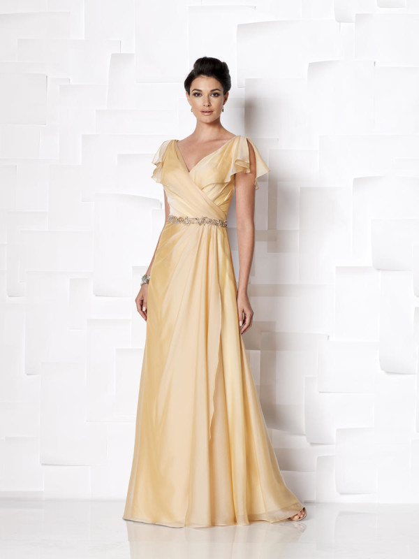 Quinceanera gown - a woman in a long dress standing against a wall
