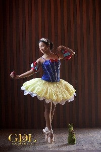 A Quinceanera dancer in a yellow and blue dress gracefully performing ballet