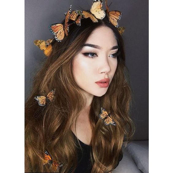 Quinceanera makeup, a woman with long hair wearing a butterfly crown