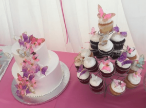 Quinceanera cake decorating: A table with a Quinceanera cake and cupcakes on it.