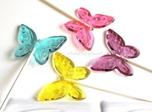 A close up of a toothpick with colorful butterflies on it at a Quinceanera butterfly party.