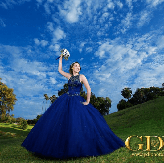 Quinceanera gown: A woman in a blue dress holding a soccer ball.
