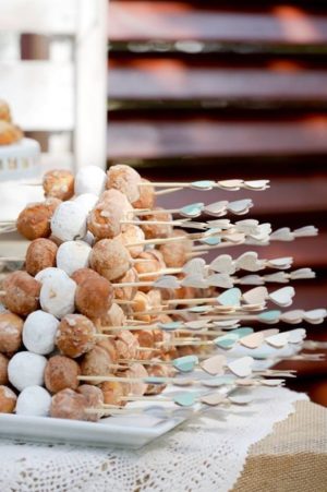 Quinceanera, a table topped with plates of donuts and skewers