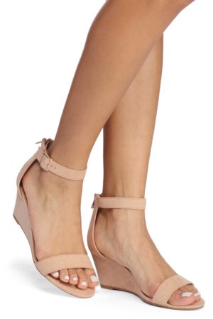 A Quinceanera's legs wearing nude colored sandals.