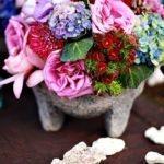 Quinceanera-themed image featuring a table with a vase filled with a beautiful flower bouquet
