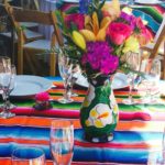 Quinceanera table, a colorful table setting with flowers in a vase