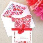 A close up of a red and white Quinceanera invitation with a paper Pan dulce design