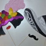 A table adorned with a Quinceanera theme featuring pan dulce, a pair of shoes, and a hat.