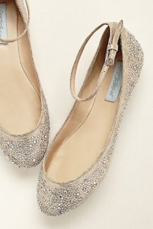 A pair of gold flats for Quinceanera, displayed on a white surface
