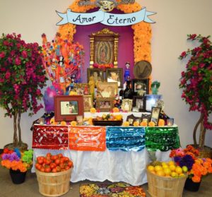 A Quinceanera themed image featuring an altares de dia de muertos Ofrenda de muertos, a table with a bunch of fruit on it