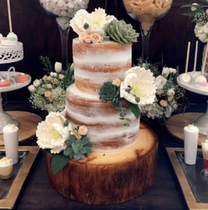 A Quinceanera cake, a three tiered cake adorned with colorful flowers and candles
