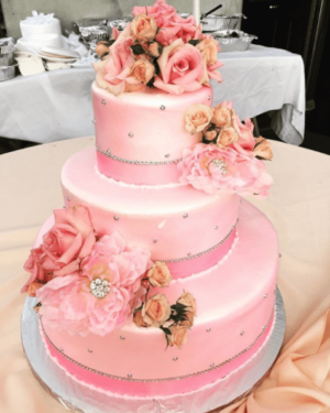 Quinceanera cake, a three-tiered cake with pink flowers on top