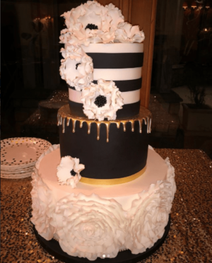 Quinceanera cake, a black and white cake with white flowers on top