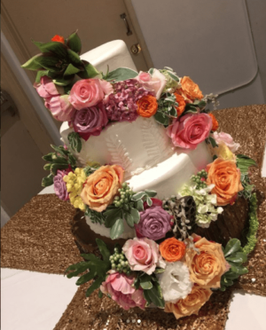 Floral design with a flower bouquet and a three-tiered Quinceanera cake decorated with flowers