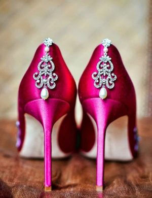 A close up of a pair of red high-heeled shoes for a Quinceanera celebration.