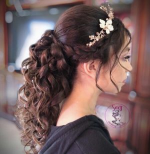 A woman with a flower in her hair wearing a Quinceanera comb for her special occasion