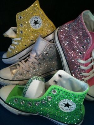 Zapatillas con brillo para niñas Trainer, a group of different colored Converses are on a blue surface for a Quinceanera event