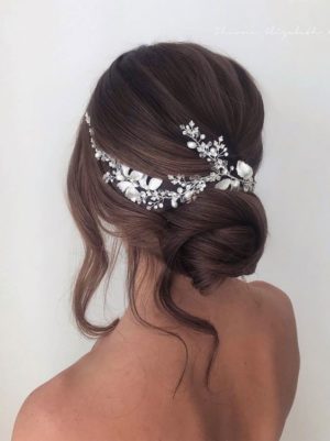 A woman with long hair wearing an elegant Quinceanera hairstyle, with a Quinceanera hair comb in her hair.
