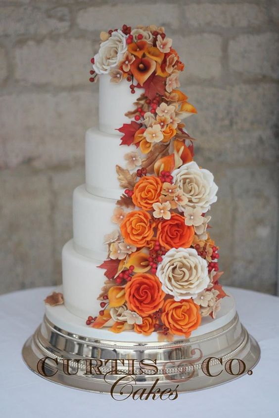A three-tiered Quinceanera cake decorated with orange and white flowers