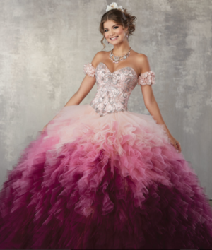 A woman in a pink and purple ombre Quinceanera dress posing for a picture