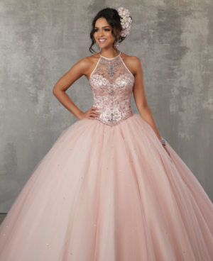 A woman in a ball gown posing for a picture, wearing Quinceañera dresses