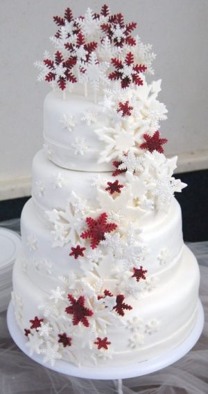 Quinceanera cake, a snowflake-inspired white cake with red and white flowers on top