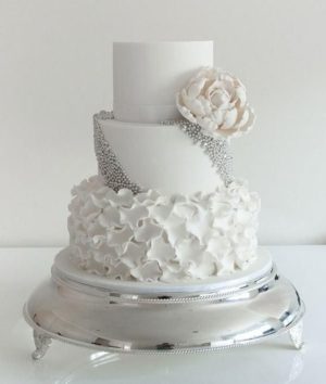 Quinceanera cake, a three tiered white cake with a flower on top