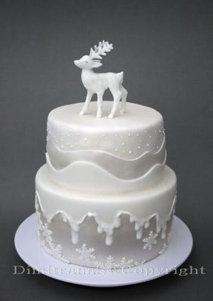 A white Quinceanera cake with a deer decoration on top