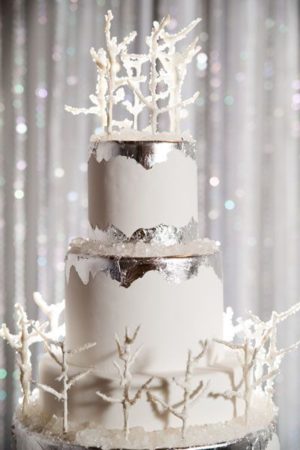 A winter themed quince cake, a three tiered cake with white frosting on a table