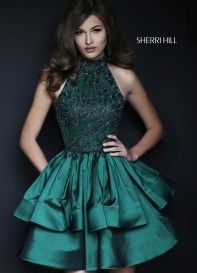 A fashion model wearing a green Quinceanera gown posing for a picture.