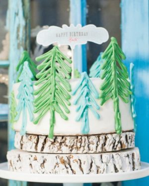 A Quinceanera cake, a white cake with green frosting and trees on it